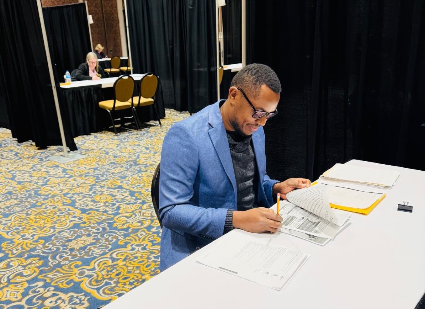 Morris Kithinji scoring competition entries at a judging table